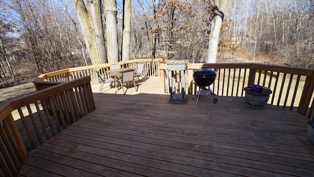 deck featuring a grill and a view of trees