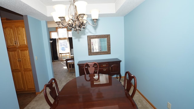 dining room featuring carpet floors, baseboards, and a notable chandelier