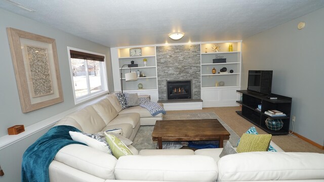 carpeted living room featuring built in shelves, a fireplace, and baseboards