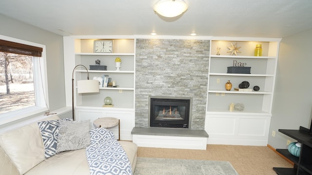 living area with built in shelves and a large fireplace