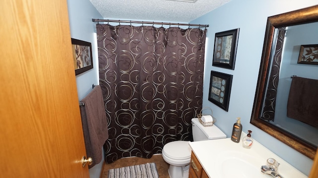 full bathroom with a textured ceiling, a shower with shower curtain, vanity, and toilet