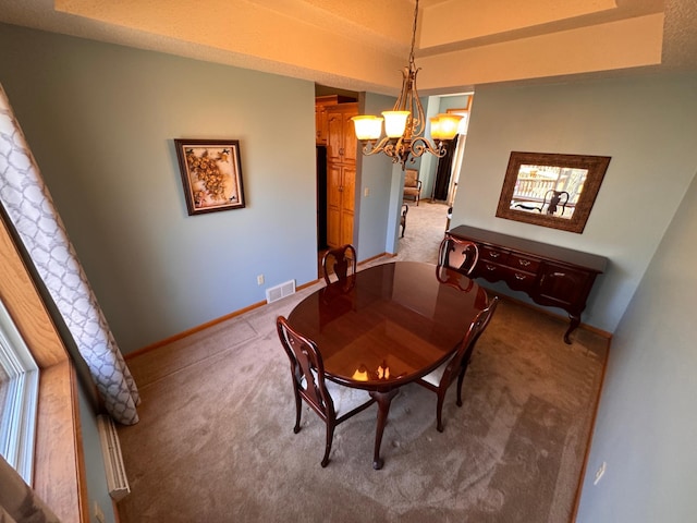 dining area with light carpet, an inviting chandelier, baseboards, and visible vents