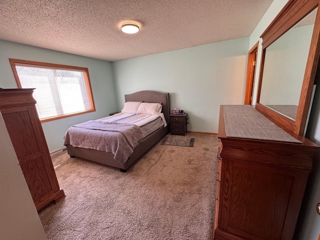 carpeted bedroom featuring a textured ceiling and baseboards