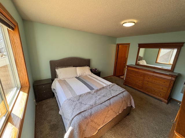 carpeted bedroom featuring a textured ceiling and multiple windows