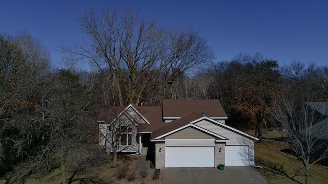 traditional-style home with a garage, brick siding, and driveway