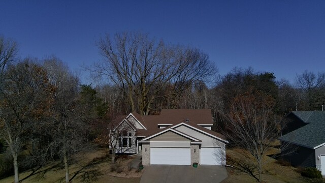 view of front of house featuring a garage, concrete driveway, and brick siding