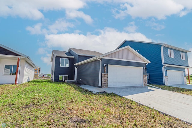 view of front of home with a garage, concrete driveway, and a front lawn