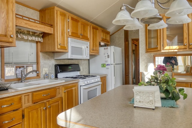 kitchen with a sink, white appliances, a wealth of natural light, and light countertops