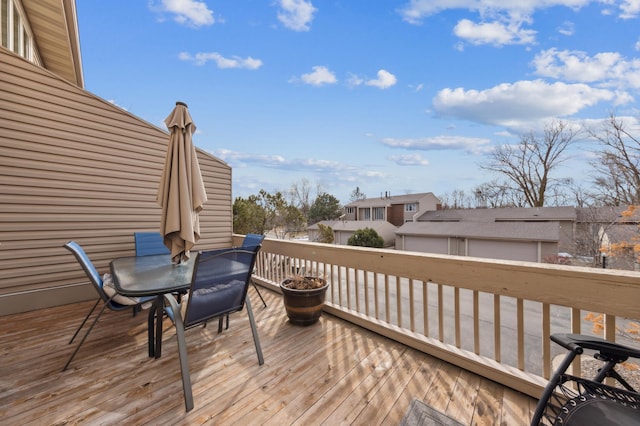 wooden terrace with outdoor dining space and a residential view