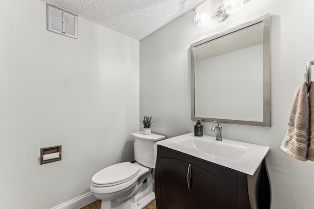 half bath with visible vents, a textured ceiling, toilet, and vanity