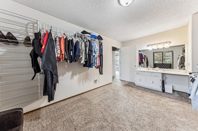 walk in closet featuring light colored carpet and a sink