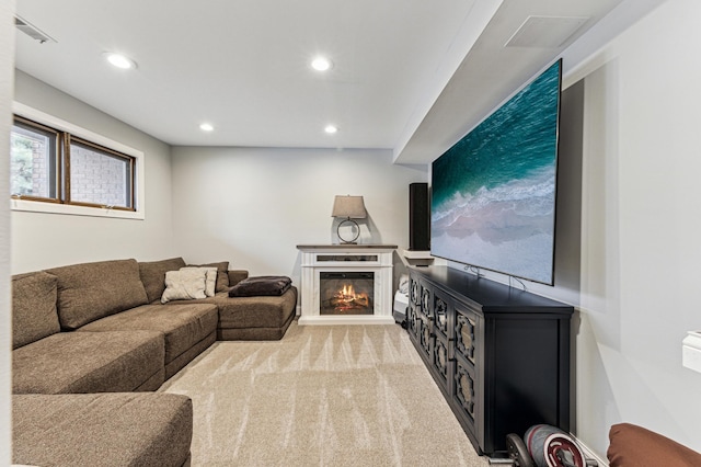 living room featuring a glass covered fireplace, recessed lighting, light colored carpet, and visible vents