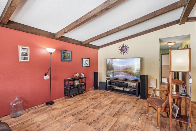 living room with vaulted ceiling with beams and wood finished floors