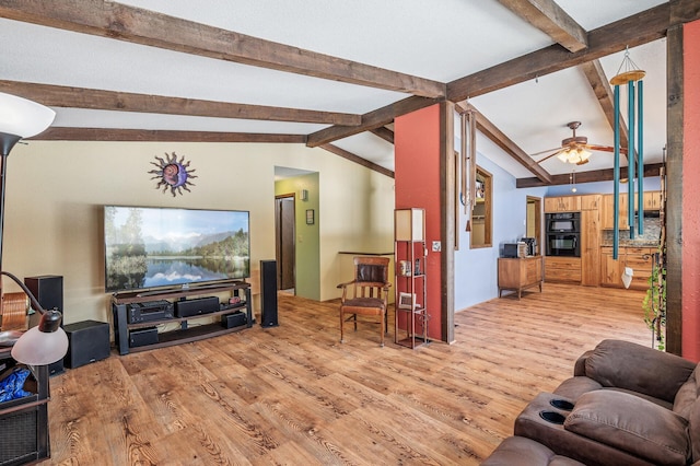 living area with vaulted ceiling with beams, light wood-style floors, and a ceiling fan