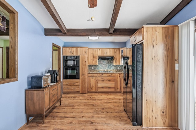 kitchen featuring light wood finished floors, backsplash, beamed ceiling, under cabinet range hood, and black appliances