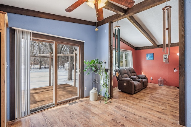 interior space featuring visible vents, ceiling fan, lofted ceiling with beams, and wood finished floors