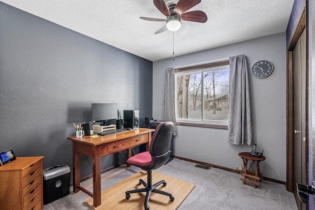 office featuring carpet, a textured wall, a ceiling fan, a textured ceiling, and baseboards