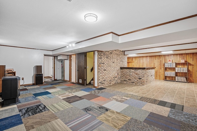 finished basement featuring a textured ceiling, wood walls, carpet flooring, stairway, and a dry bar