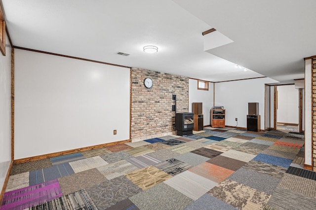 finished below grade area with a wood stove, carpet floors, baseboards, and visible vents