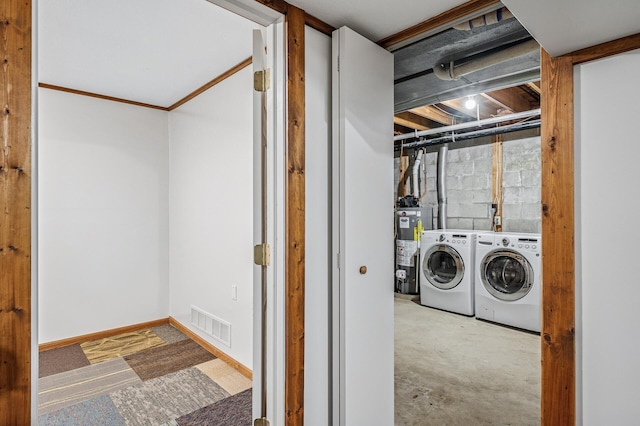 washroom with gas water heater, laundry area, visible vents, baseboards, and independent washer and dryer