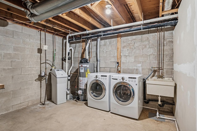 washroom featuring water heater, laundry area, a sink, and washer and dryer