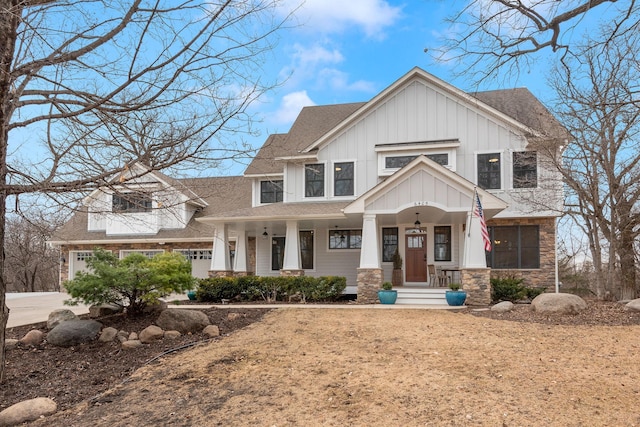 view of front of house featuring stone siding, roof with shingles, board and batten siding, and concrete driveway