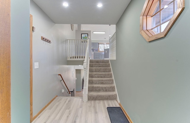 stairway with wood finished floors and baseboards