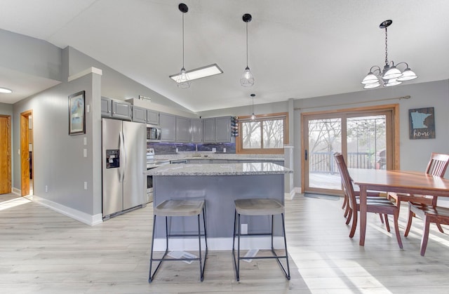 kitchen featuring plenty of natural light, a center island, stainless steel appliances, and gray cabinetry