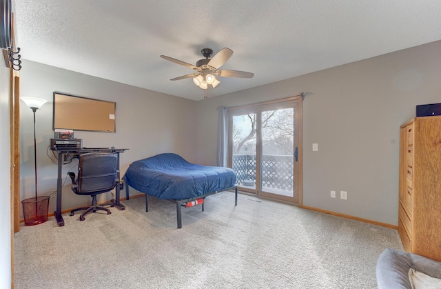 carpeted bedroom with access to exterior, a textured ceiling, baseboards, and a ceiling fan