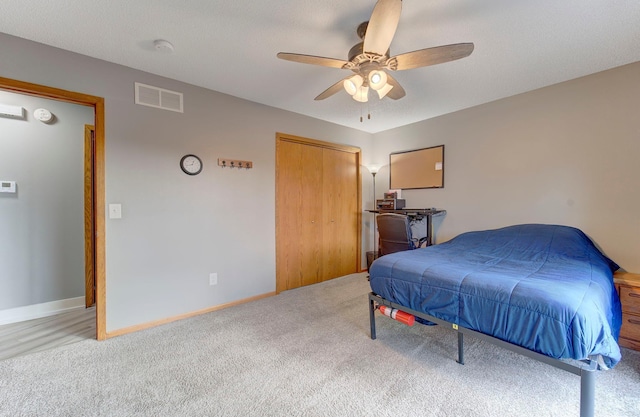 bedroom featuring a closet, visible vents, a ceiling fan, carpet flooring, and baseboards