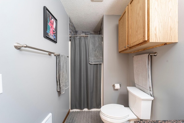 bathroom featuring toilet, a textured ceiling, and a shower with shower curtain