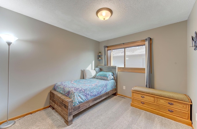 carpeted bedroom with a textured ceiling and baseboards