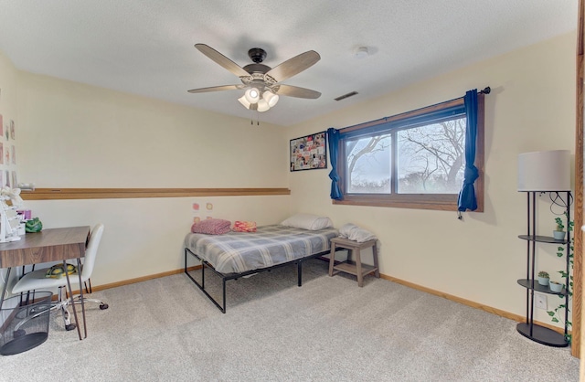 bedroom with a textured ceiling, carpet floors, a ceiling fan, visible vents, and baseboards