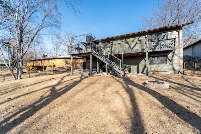 back of property featuring a fire pit, fence, stairway, and a wooden deck