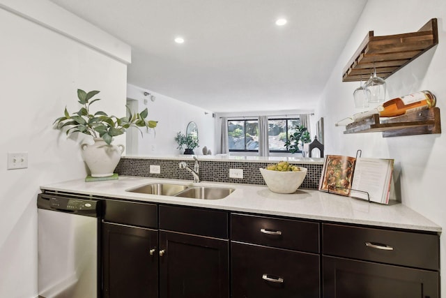 kitchen with stainless steel dishwasher, recessed lighting, a sink, and light stone countertops