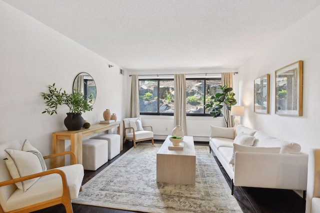 living area with visible vents, a textured ceiling, and wood finished floors