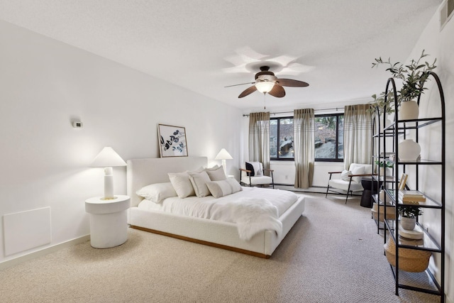 carpeted bedroom with a ceiling fan, visible vents, baseboards, and a textured ceiling