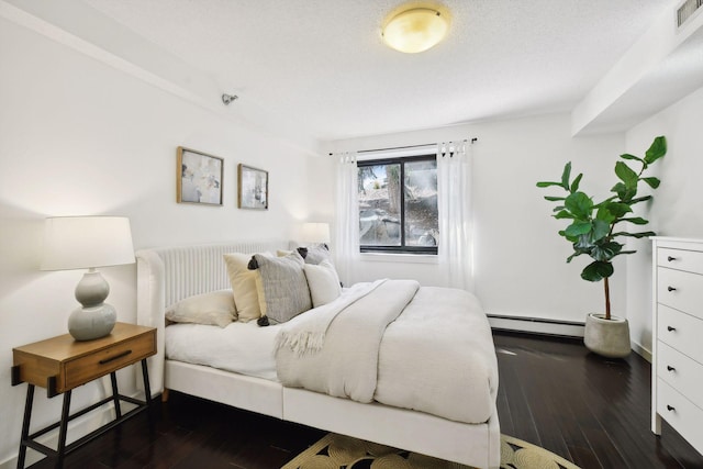 bedroom featuring dark wood-style flooring, baseboard heating, and visible vents