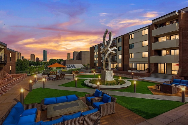 surrounding community featuring a view of city, a patio, and an outdoor living space