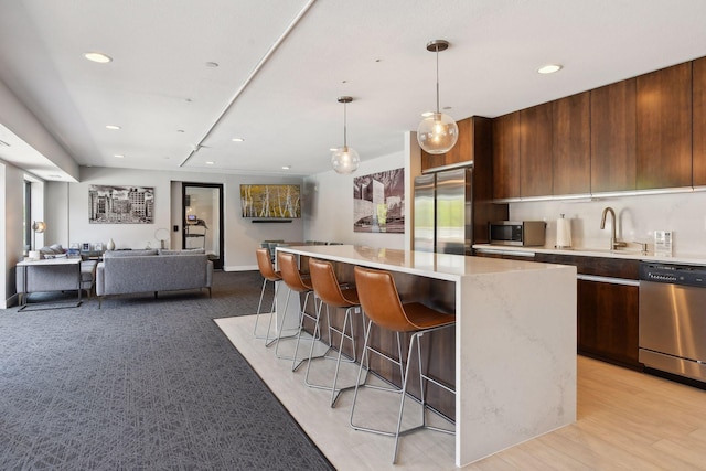 kitchen featuring a kitchen island, modern cabinets, appliances with stainless steel finishes, and a kitchen breakfast bar