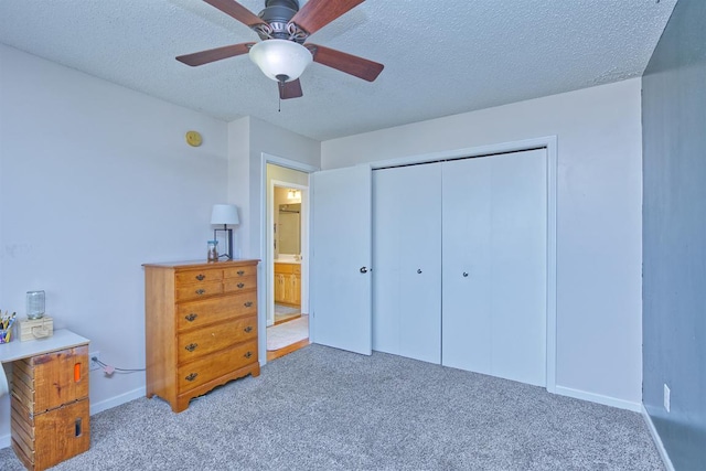 carpeted bedroom with a textured ceiling, ceiling fan, a closet, and baseboards