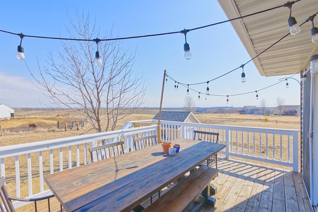 wooden terrace featuring outdoor dining area and a rural view