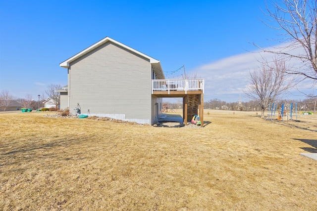 view of side of home with a deck and a yard