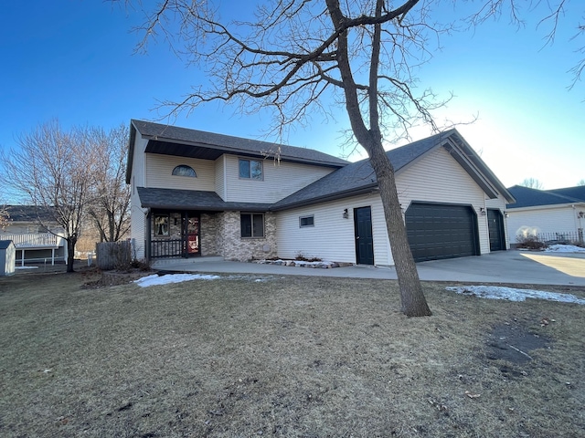 traditional-style home with covered porch, an attached garage, concrete driveway, and a shingled roof