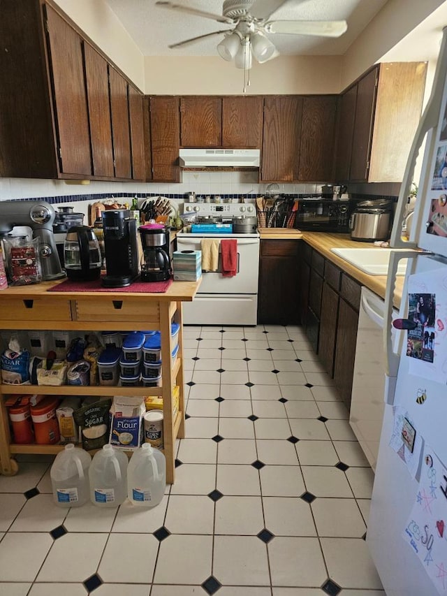 kitchen featuring tasteful backsplash, light countertops, a ceiling fan, white appliances, and under cabinet range hood