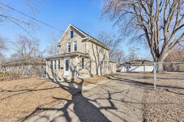 view of front of property featuring an outdoor structure and fence