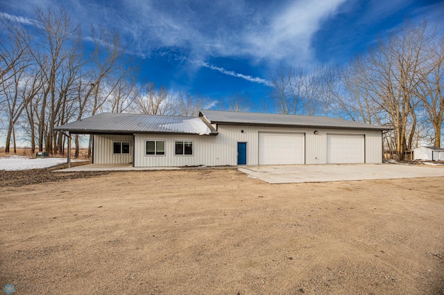 view of front of home with driveway and metal roof