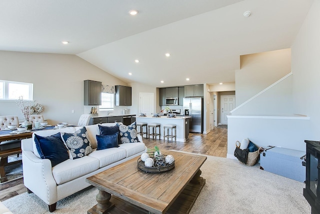 living room with light wood-style flooring, vaulted ceiling, and recessed lighting