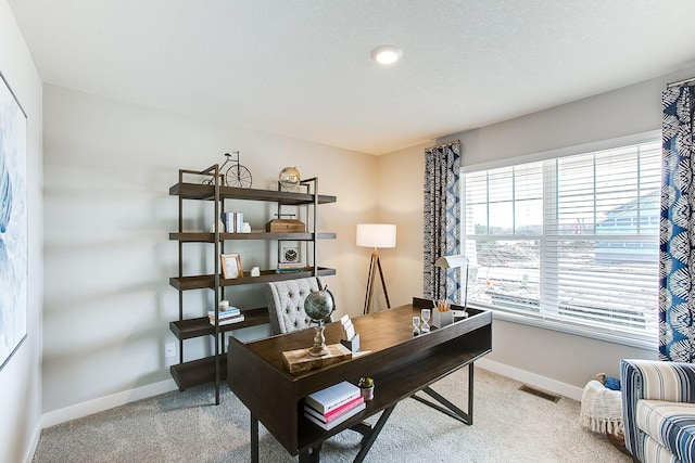 office space with light carpet, baseboards, visible vents, and a textured ceiling