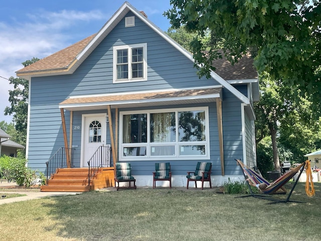 bungalow featuring a shingled roof and a front yard